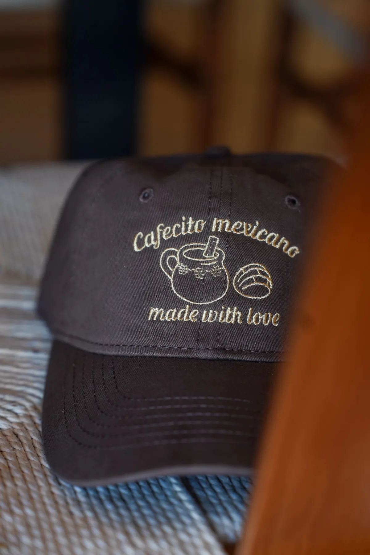 Brown Cafecito Mexicano embroidered cap displayed at the café